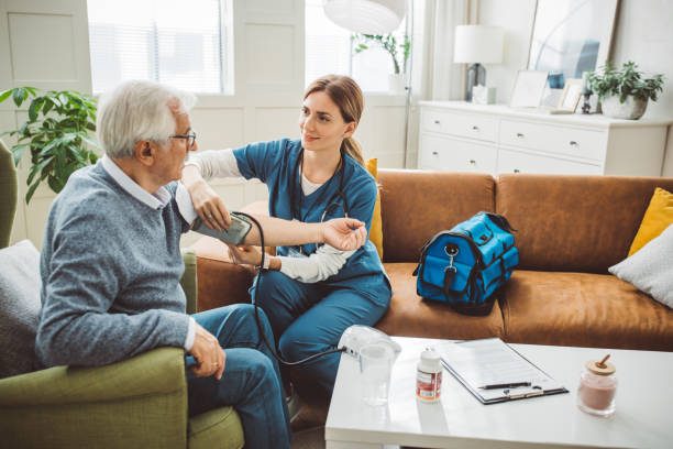 A nurse checking a client's blood pressure during an in-home visit