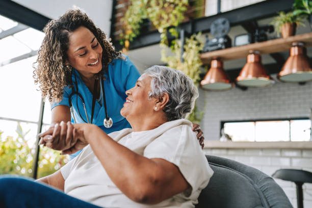 A caregiver spending time with a senior in a bright, home-like living room